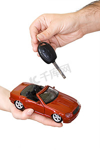 credit摄影照片_Hands with red sports car and key