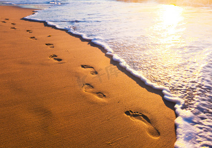 海滩、 波和在日落时的脚步声