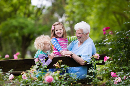 祖母和孩子坐在玫瑰花园