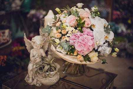 粉色花朵小花朵摄影照片_美丽精致的花束在桌子上。花的主题。白色和粉红色