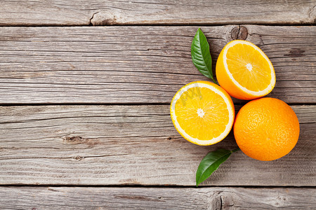 夏天橙子摄影照片_木制桌子上的新鲜橙子
