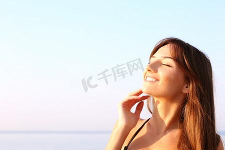 年轻女子在大海背景上晒日光浴
