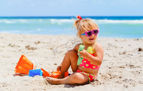 可爱的小女孩在沙滩上玩沙子