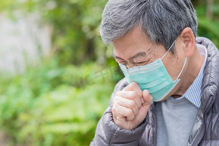 老中医给老人号脉摄影照片_老人感冒了, 戴着面具在户外