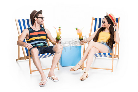 沙滩椅摄影照片_夫妇放松的沙滩椅与鸡尾酒和凉爽的盒子, 在白色隔离