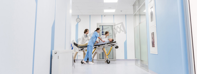 集中的医生和护士在轮床上运送无意识病人 