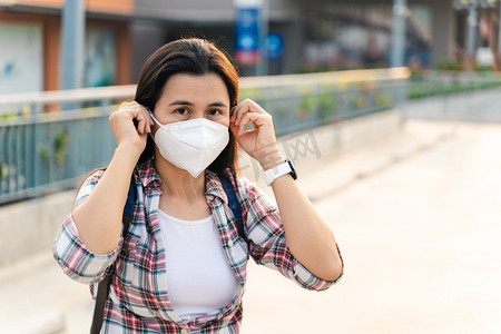 亚洲女人戴著N95口罩以防止污染Pm2.5和病毒。Covid-19 Coronavirus and Air pollution pm2.5 concept.