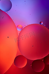 紫色宇宙摄影照片_红色和紫色混合水和油的美丽的抽象背景