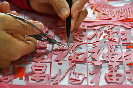 剪纸传统文化摄影照片_2019年1月10日，在中国东部山东省烟台市的一个车间里，一位女工匠制作了一件百个汉字
