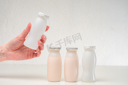 person摄影照片_Prevention of dysbacteriosis. Live yoghurts. Foods contain beneficial bacteria. Care for digestion. A person is holding a yogurt with lacto and bifidobacteria.