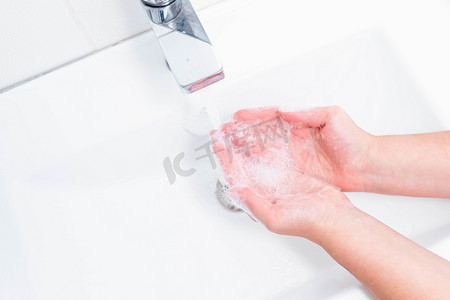 洗脸服务摄影照片_用人的肥皂和水洗手以防止考拉韦病毒，卫生以防止考拉韦病毒的传播。女人用肥皂在水龙头下洗手。手部卫生概念细节.