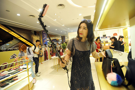 京东2016摄影照片_2016年9月10日, 中国一位网播女主人在中国中部湖北省武汉市的一家购物中心用她的智能手机进行直播流媒体网播