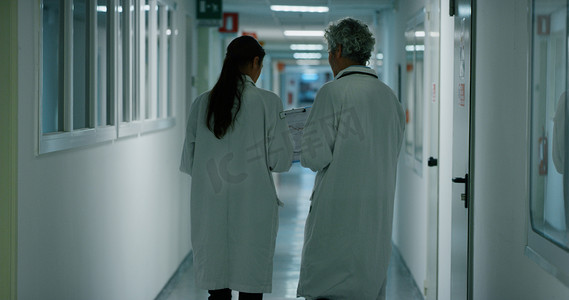 医生和护士讨论病人在医院病房散步时的诊断问题, 以便为他今后的治疗提供建议。医学、技术、保健和人、医院的概念