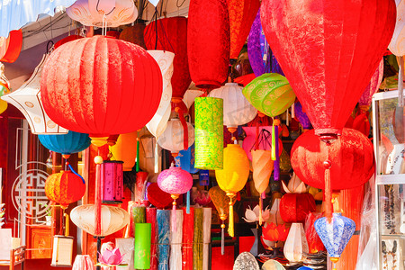 在越南海安街头市场的一家商店里出售色彩艳丽的丝绸灯笼。它们都是手绘的，有花卉、鸟类和房屋的图案.
