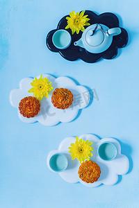 灯笼月亮摄影照片_月饼，蓝茶壶，黄菊花。中国中秋节食品.