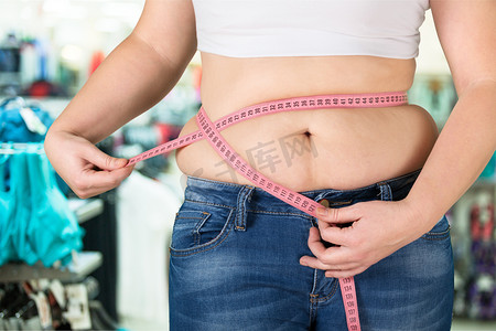 胖女人测量她的胃