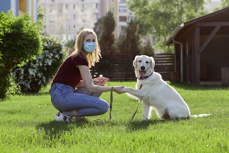 科罗纳威斯大流行病戴着防护面具的小女孩在夏天的公园里遛狗，一个带着小狗在隔离室里的女人