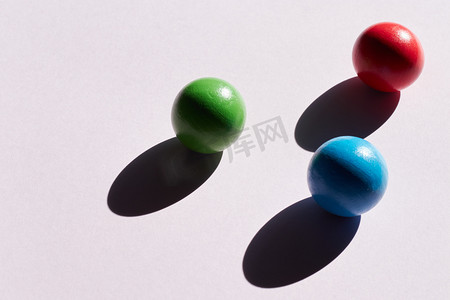 光背景上的三个彩色球，带有硬阴影。抽象背景的设计。复制空间几何体