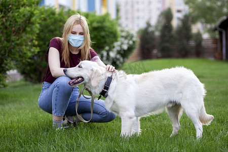 科罗纳威斯大流行病戴着防护面具的小女孩在夏天的公园里遛狗，一个带着小狗在隔离室里的女人