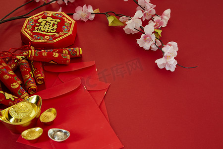 春意昂仁摄影照片_中国新年2019年节日装饰. 鞭炮, 金锭, 红包, 梅花, 在红色的背景。顶部视图配件。翻译: 傅意思是好运, 春意春天.