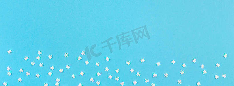 蓝色背景长图摄影照片_创意的顶部视图平躺冬季框架。概念冬季图案由小白雪花柔和蓝色背景复制空间极简模板邀请卡长宽横幅
