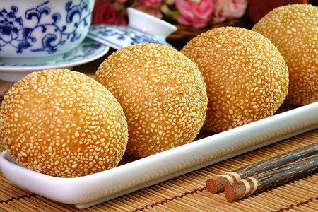 芝麻球摄影照片_芝麻球（英语：Sesame Ball）是由面粉制成的油炸甜点球，里面塞满了调料的绿豆、红豆、黑豆或花生酱，并涂上了白芝麻。也被称为龙珠，是中国著名的小吃