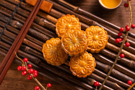 月饼背景摄影照片_中国传统糕点月饼月饼与茶杯在竹盘上的木背景中秋节，顶视图，平铺.