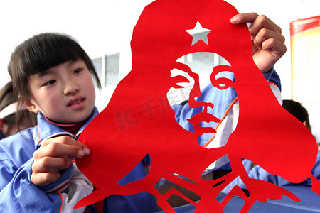 文化展示摄影照片_2013年3月4日，在中国东部的山东省赵庄市，一名学生展示了她的雷锋（或雷锋）头像的剪纸作品