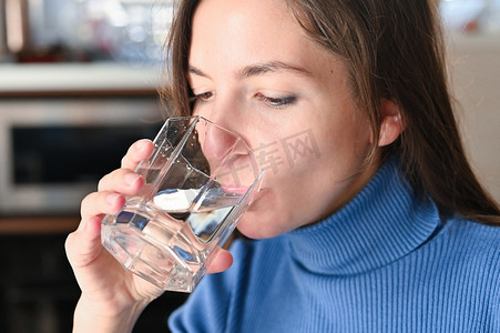 喝大量的水从病毒，Covid-19大流行的大肠癌。女孩从杯子里喝水.