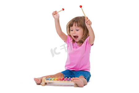 可爱的微笑开朗积极的女孩3岁的演奏乐器玩具木琴孤立在白色背景.