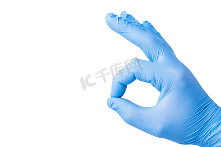 戴蓝色胶乳手套的人的手，白底上有手指，显示出良好的标志.