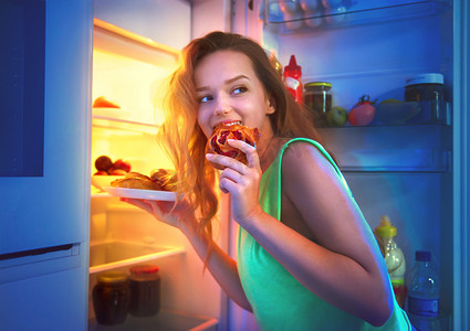  姑娘在晚上把食物从冰箱