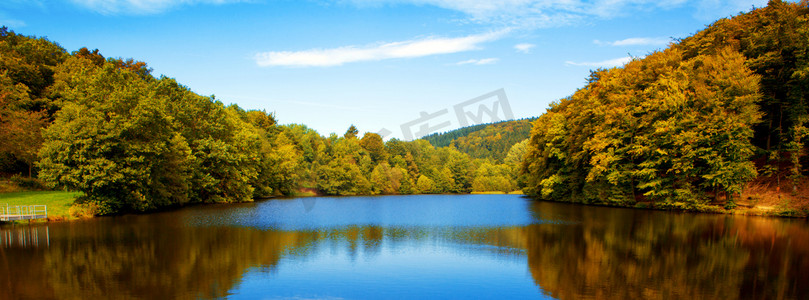 秋天风景天空摄影照片_在秋天的树林用反射湖.