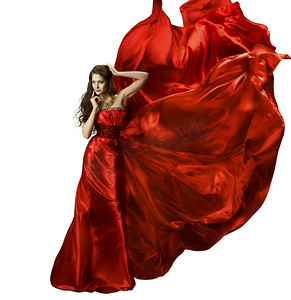 红色丝绸创意摄影照片_女人美容时尚服饰、 优雅的红色丝绸长袍挥舞着织物，飘飘龙布在风力发电、 孤立在白色的背景模型中的女孩