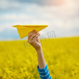 纸飞机在孩子们手上黄色背景和蓝 s