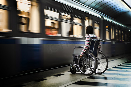 轮椅治疗摄影照片_坐在轮椅上在地铁站的女人