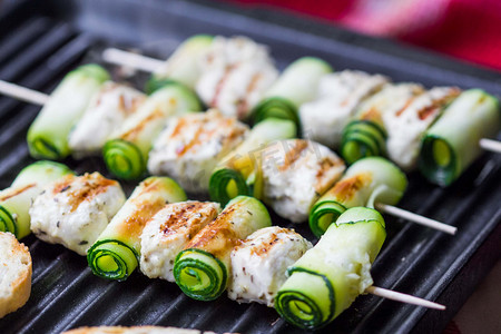 烹饪烤鸡肉串、 串在热轧西葫芦扦子上,