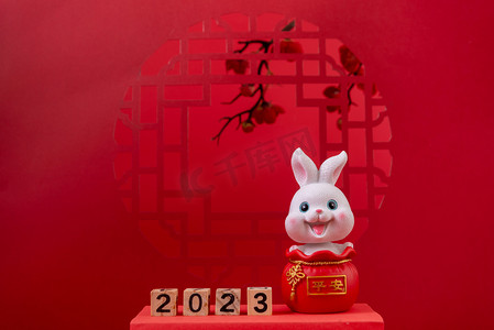 2023春节摄影照片_新年春节兔年红色背景摆放摄影图配图