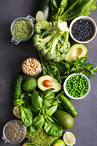 设置生鲜健康食品清洁食源蛋白质的素食者: 黄瓜, 苜蓿, 西葫芦, 菠菜, 罗勒, 青豆, 鳄梨, 花椰菜, 石灰, 黑豆和绿色小扁豆在黑色背景, 顶部视图