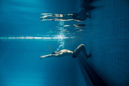 泳池游泳镜中年轻游泳运动员的水下图片
