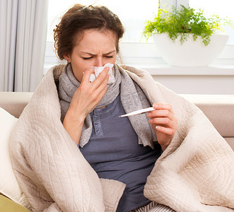 发烧温度摄影照片_生病的女人。流感。女人得了感冒。打喷嚏入组织