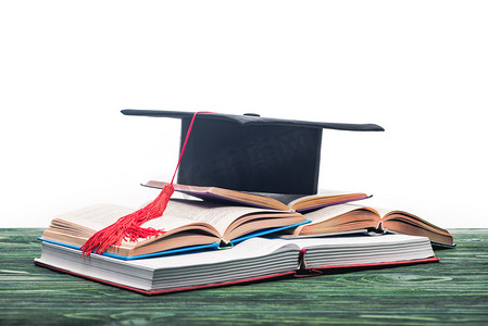 Open books with graduation cap on top