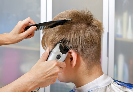 剪头发摄影照片_通过特殊的机器为发型男士发型