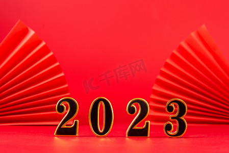 2023春节摄影照片_新年元旦2023红色背景上摆放摄影图配图