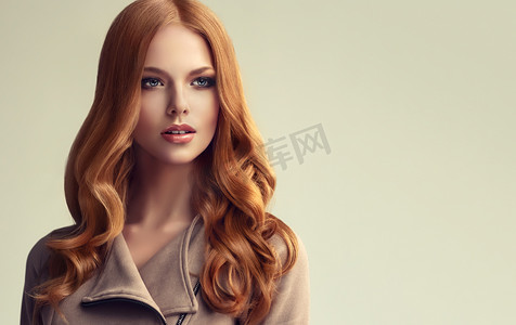 红头发的女孩, 长而闪亮的卷发。美丽的模型妇女与卷曲的发型。头发的护理和美容