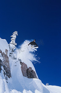 冬季运动健身摄影照片_滑雪者从山窗台上跳下来