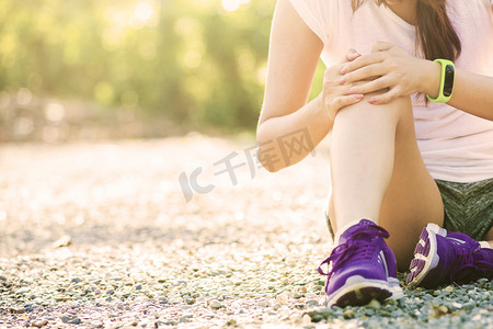 跑步运动膝关节损伤。同时在公园跑步的痛苦的女人