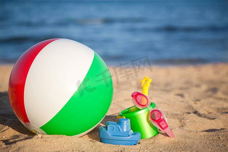 孩子们在海滩上玩沙子和充气球的玩具。暑假概念