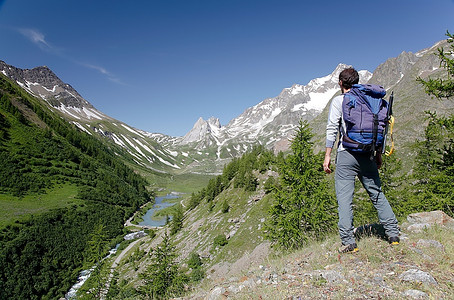 米奇摄影照片_一名男性徒步旅行者正在欣赏意大利库马约尔勃朗峰米奇湖的美丽风景