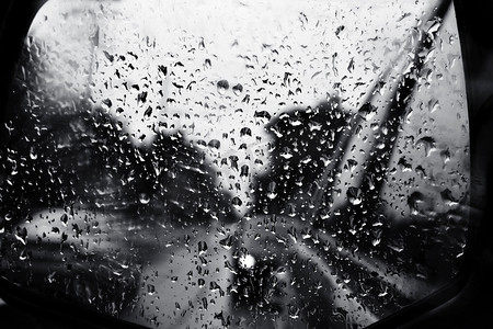 雨滴的汽车镜在一个灰色的孤独的雨天。